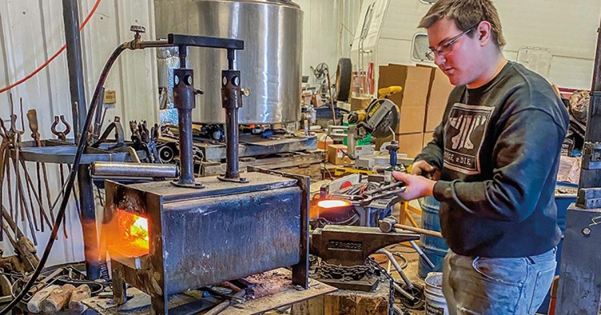 Gabe Jensen, 17, heats a knife blade in his gas-fired forge so he can start shaping the metal with a hammer.