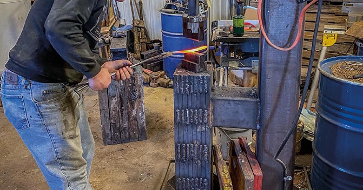 Using a 100-pound power hammer constructed by his father, Gabe Jensen applies more pressure to the heated steel to force it into the shape of a knife blade.
