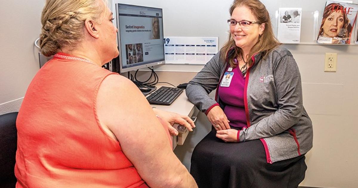 Kay Way, left, visits with Linda Wolf, a genetic counselor at Bismarck’s Sanford Health who guides patients through the decision-making and genetic testing process. Photo by NDARECc/Liza Kessel