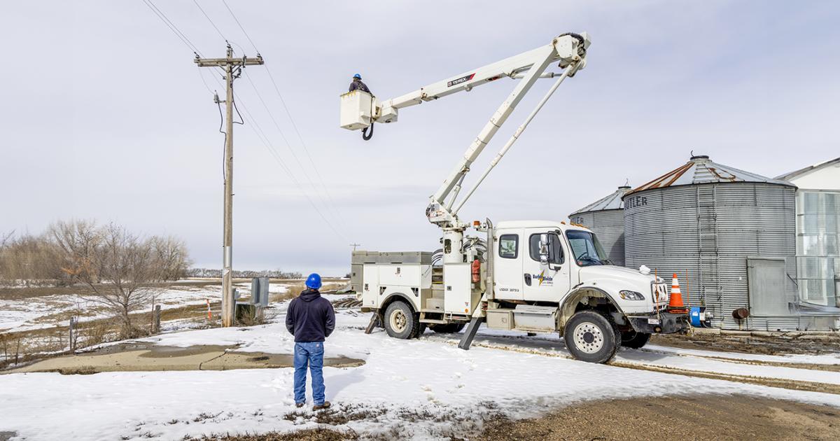 Line Foreman Jason Bruner looks on as Lineworker Terry Knutson inspects an overhead distribution line near Kenmare.